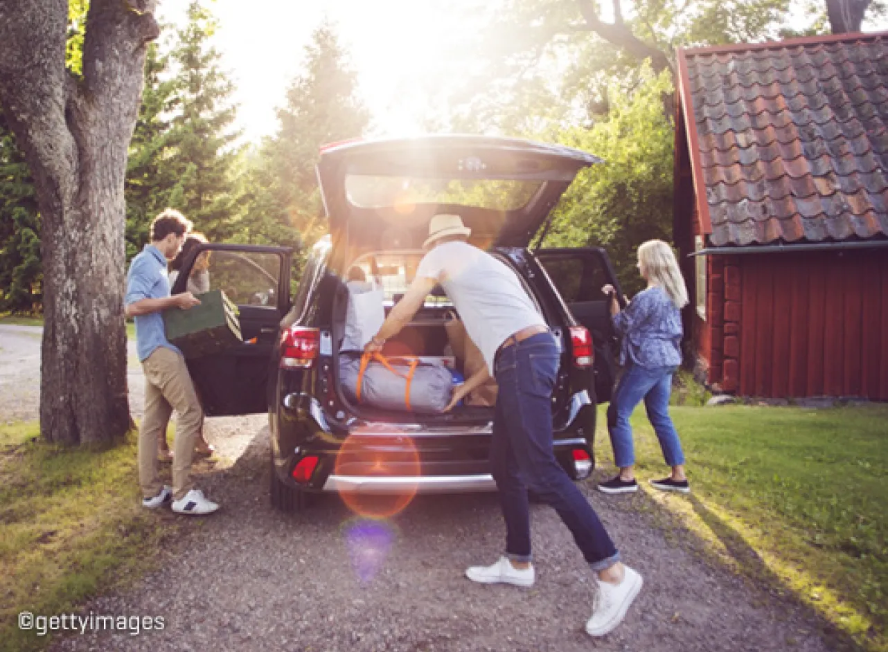 Une famille remplit sa voiture de valises